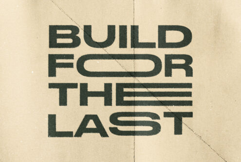 Dark green uppercase letters Build For Last on cream with diagonal seams