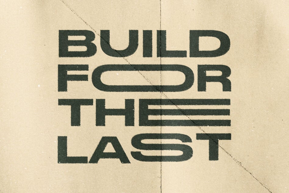 Dark green uppercase letters Build For Last on cream with diagonal seams