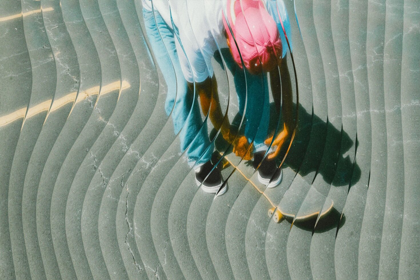 Overhead shot of colorful sneakers on curved pavement creating shadow effects with ripple pattern