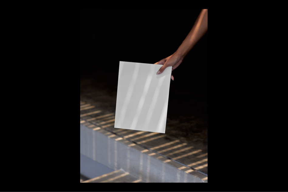 A hand holds a blank paper in natural light ideal for mockup presentations. Use for showcasing stationery or design projects. Designer asset SEO keywords.