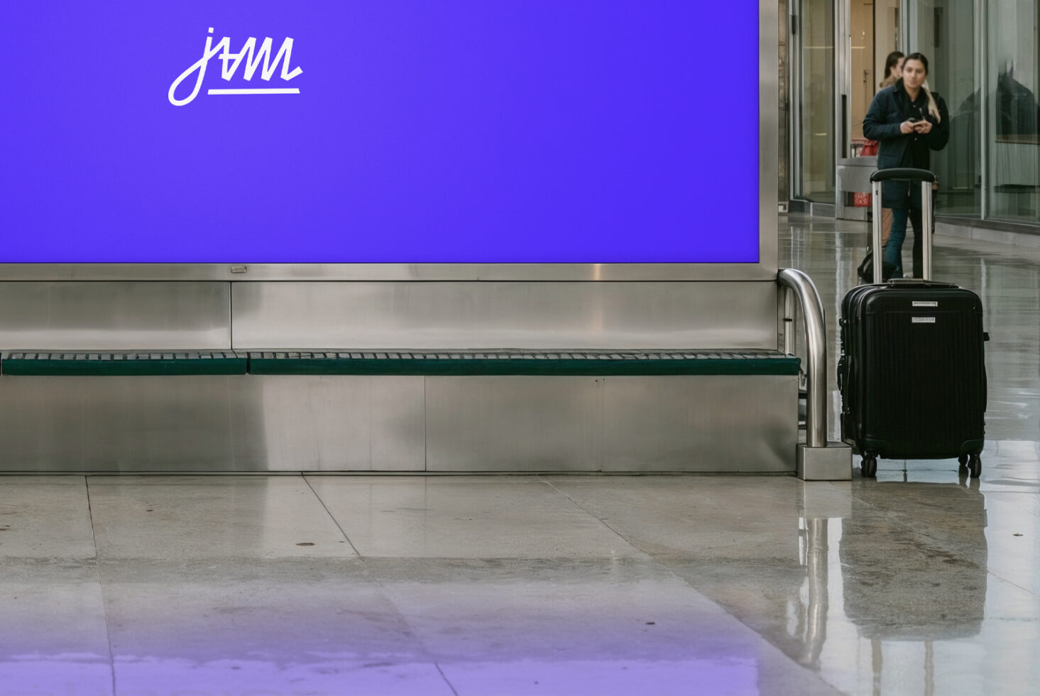 Purple billboard with white script logo in empty transit station with luggage
