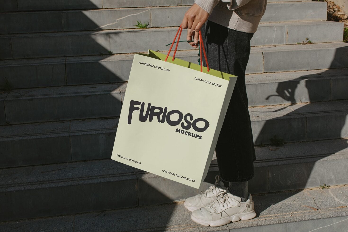 Cream shopping bag with black Furioso text, red handles outdoor concrete backdrop