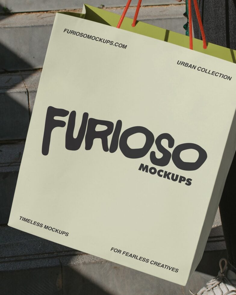 Cream paper bag with black Furioso Mockups text, red handles close-up view