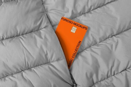 Bright orange credit card with chip on quilted gray fabric background