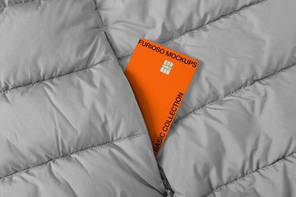 Bright orange credit card with chip on quilted gray fabric background
