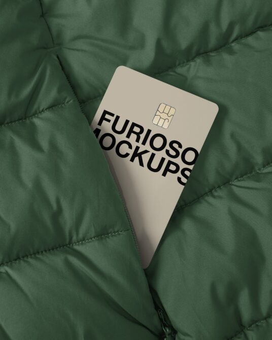 Cream colored credit card with black text on green quilted jacket surface