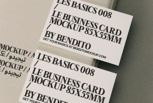 Two cream business cards overlapping on beige background with Les Basics text