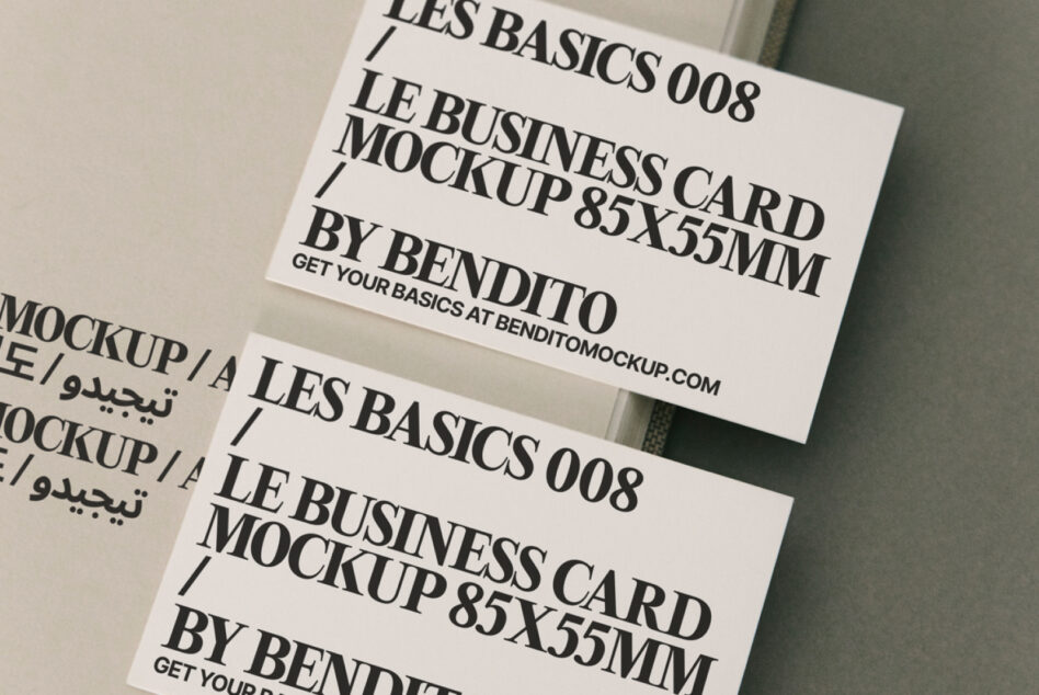 Two cream business cards overlapping on beige background with Les Basics text