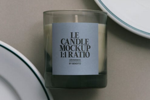 Glass candle with blue label, ceramic plate rim visible overhead