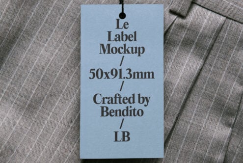 Light blue hang tag draped on pinstriped fabric, displaying Le Label Mockup 50x91.3mm