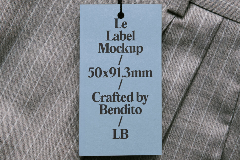 Light blue hang tag draped on pinstriped fabric, displaying Le Label Mockup 50x91.3mm