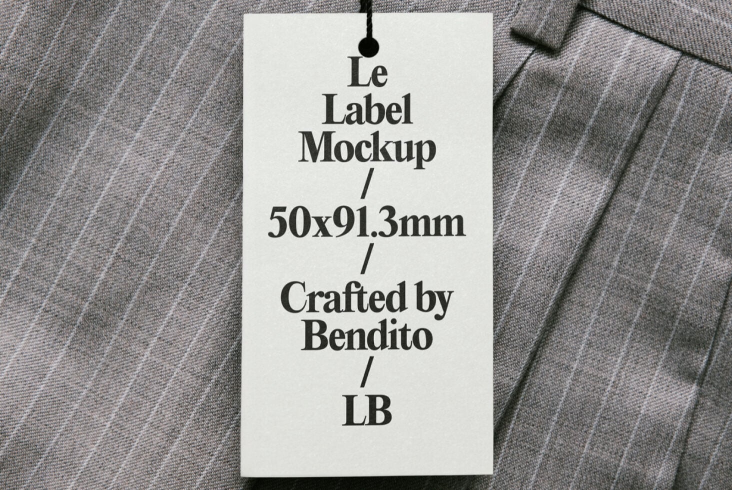 Cream hang tag on textured fabric with black cord showing Le Label Mockup text