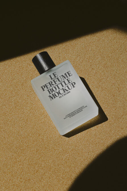 Square white fragrance bottle with black cap casting shadow on beige linen textured surface
