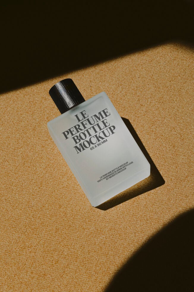 Square white fragrance bottle with black cap casting shadow on beige linen textured surface