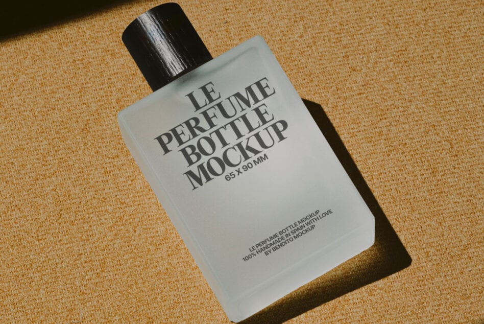 White cologne bottle with black spray cap on warm sand colored woven textile background