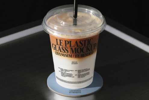 Coffee beverage in clear plastic cup with dome lid, metal straw visible