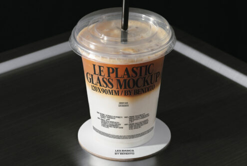 Clear plastic cup with straw filled with iced coffee drink, white label mockup showing branding