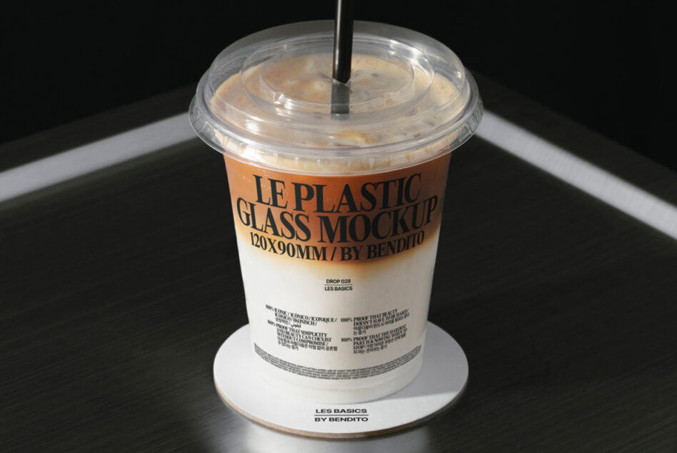 Clear plastic cup with straw filled with iced coffee drink, white label mockup showing branding