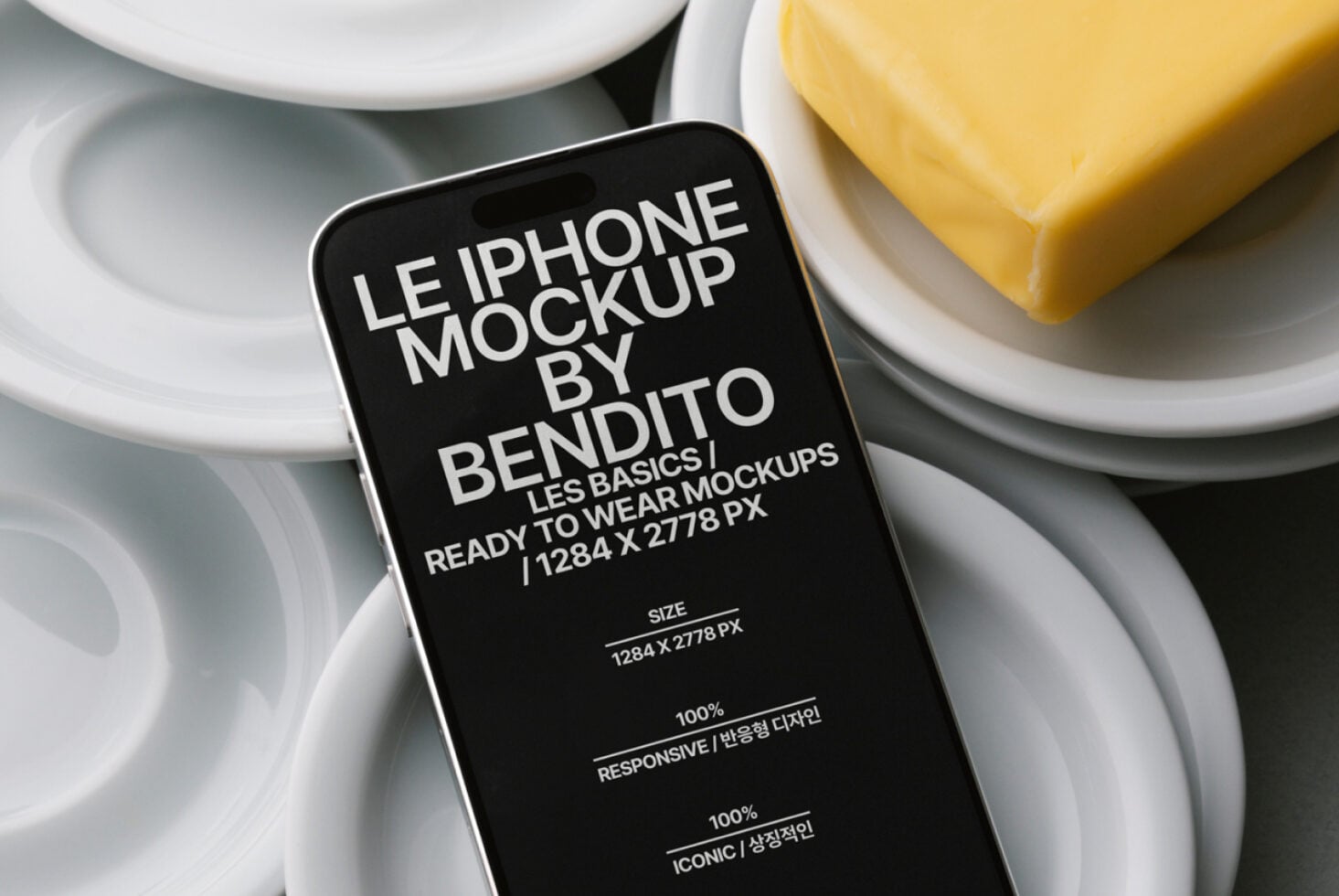 Dark iPhone mockup centered on white plate with butter bar nearby