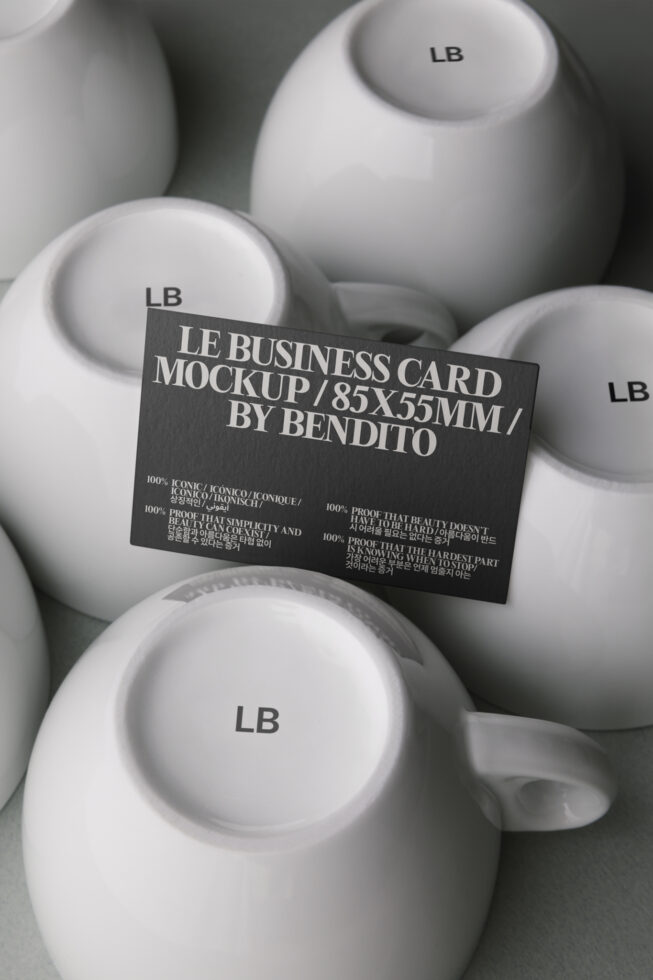 Black business card draped over white ceramic cups with LB branding stamped