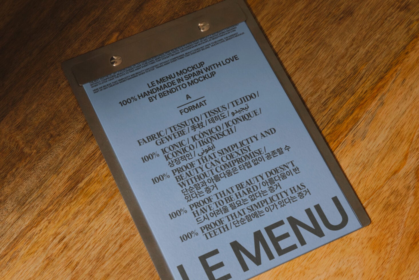 Blue menu mockup with metal clips on wood grain showing handmade typography