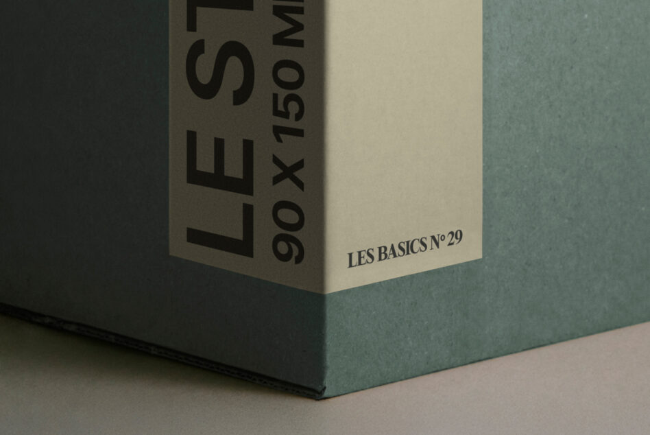 Close-up corner shot of white box with teal surface showing Les Basics branding