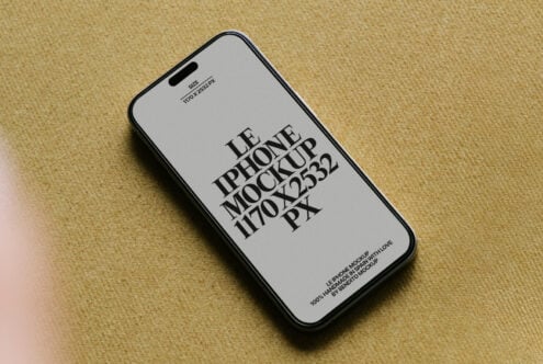 iPhone 14 Pro mockup on beige fabric with light screen displaying typography