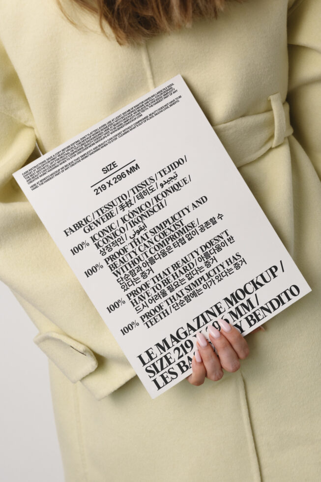 Magazine mockup with multilingual text held against cream oversized blazer