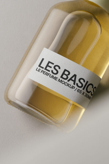 Golden perfume bottle with white label in cream colored box, angled view