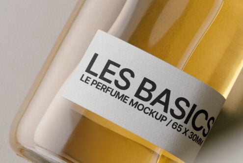 Golden perfume bottle with white label in cream box on neutral background