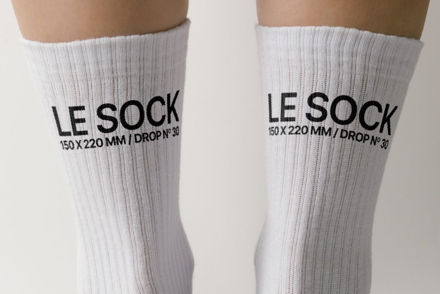 White crew socks with black text reading LE SOCK 150 X 220 MM DROP No 30