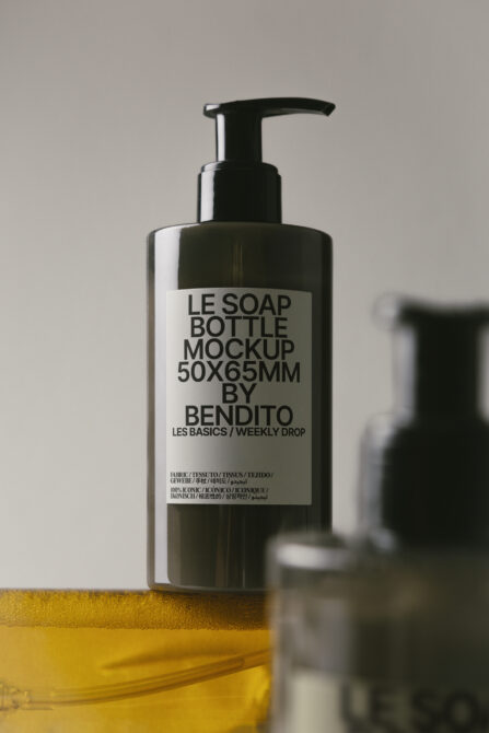 Black soap dispenser bottle with white label over yellow surface detail