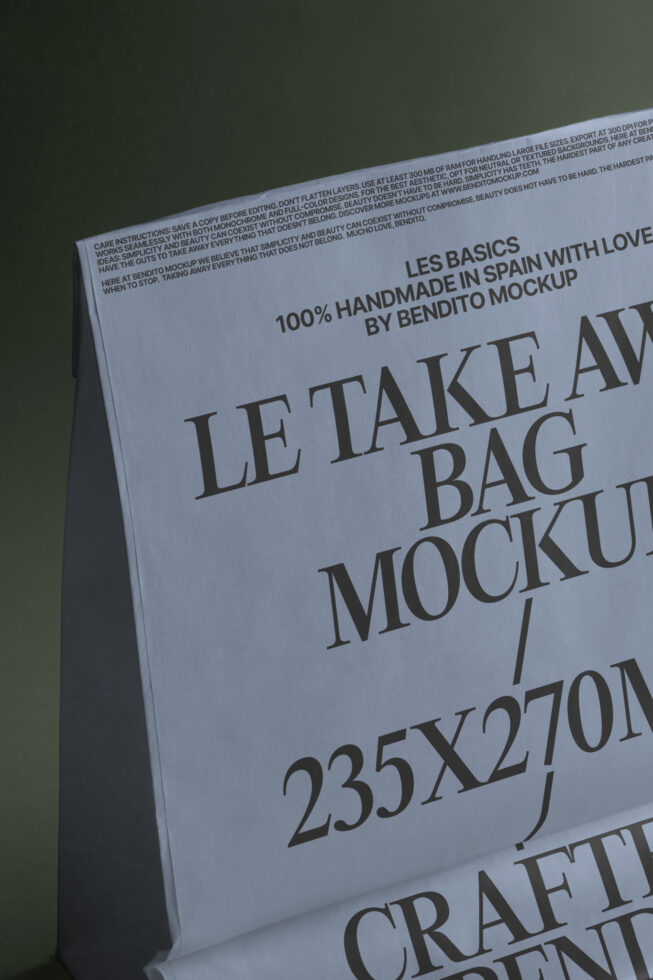 Close-up of folded white paper tote bag showing Les Basics text in serif font