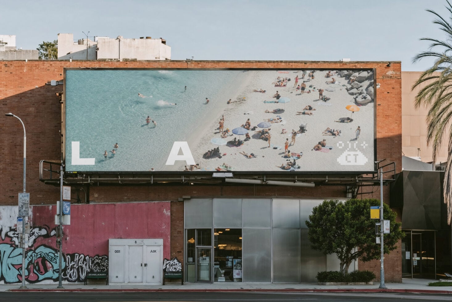 Billboard showing aerial beach photo with L A CT text overlay above storefront