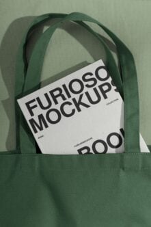 Green canvas tote bag holding branded mockup documents inside