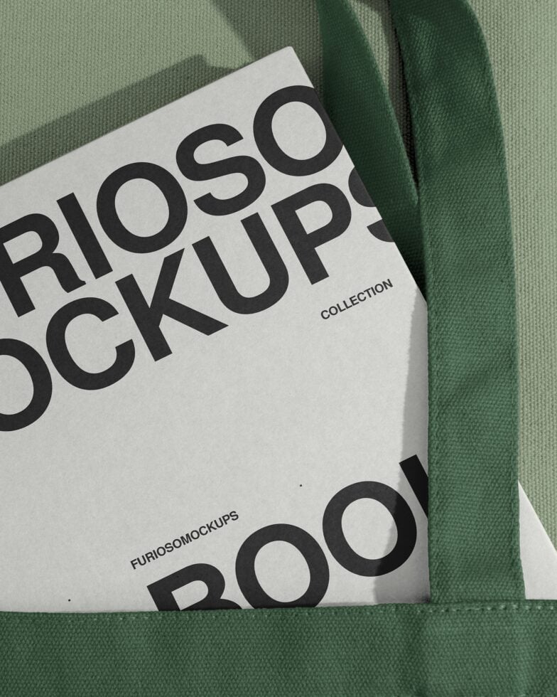 Close up of white paper mockup draped over green fabric with bold text
