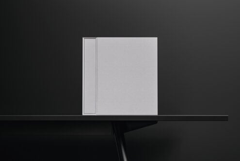 Blank hardcover book mockup with dust jacket, front view on dark surface