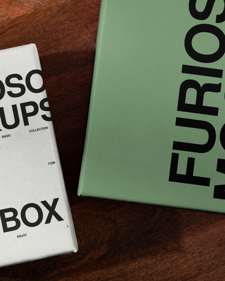 White box with green cover on wooden table styled flat lay