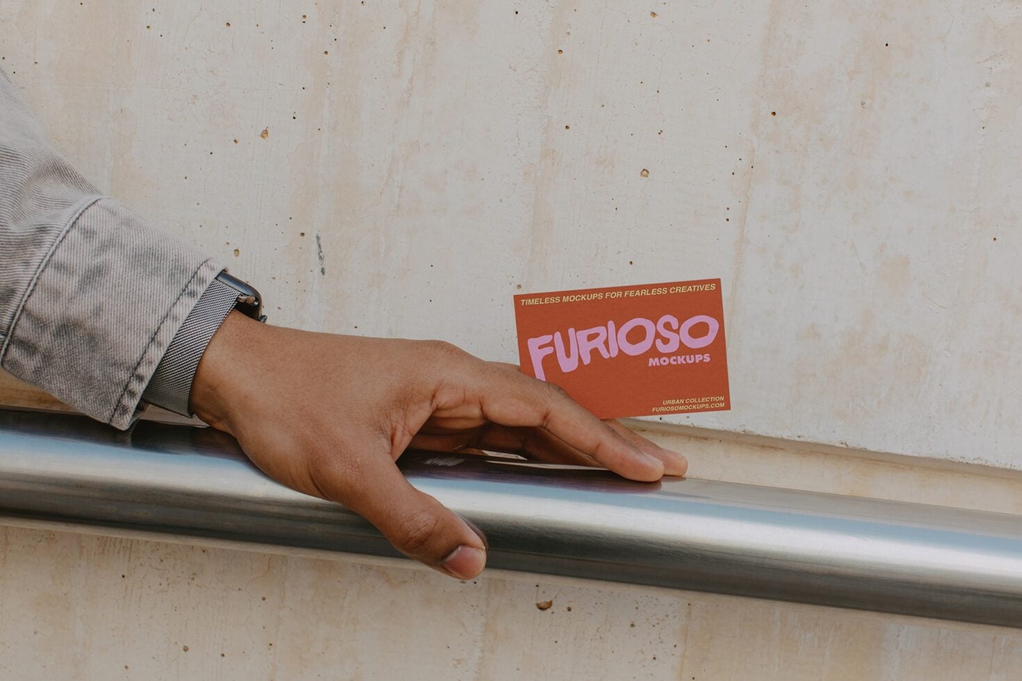 Hand on metal rail holding rust card with pink FURIOSO text