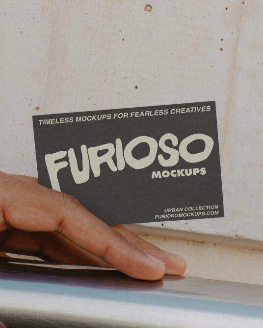 Hand holding dark business card with cream FURIOSO text mockup