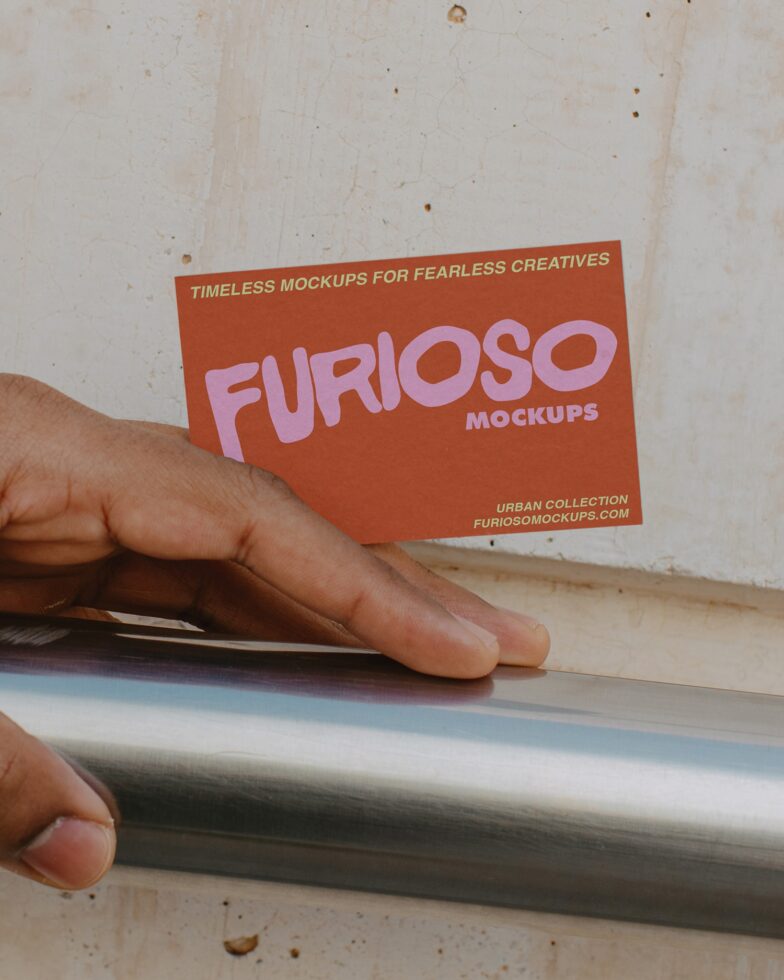 Hand holding rust business card with pink FURIOSO text mockup
