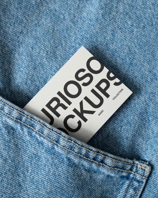 White printed card sitting in blue denim pocket with visible stitching