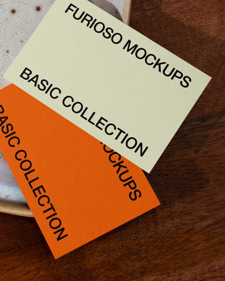 Cream orange cards overlapping on textured wood with speckled ceramic dish