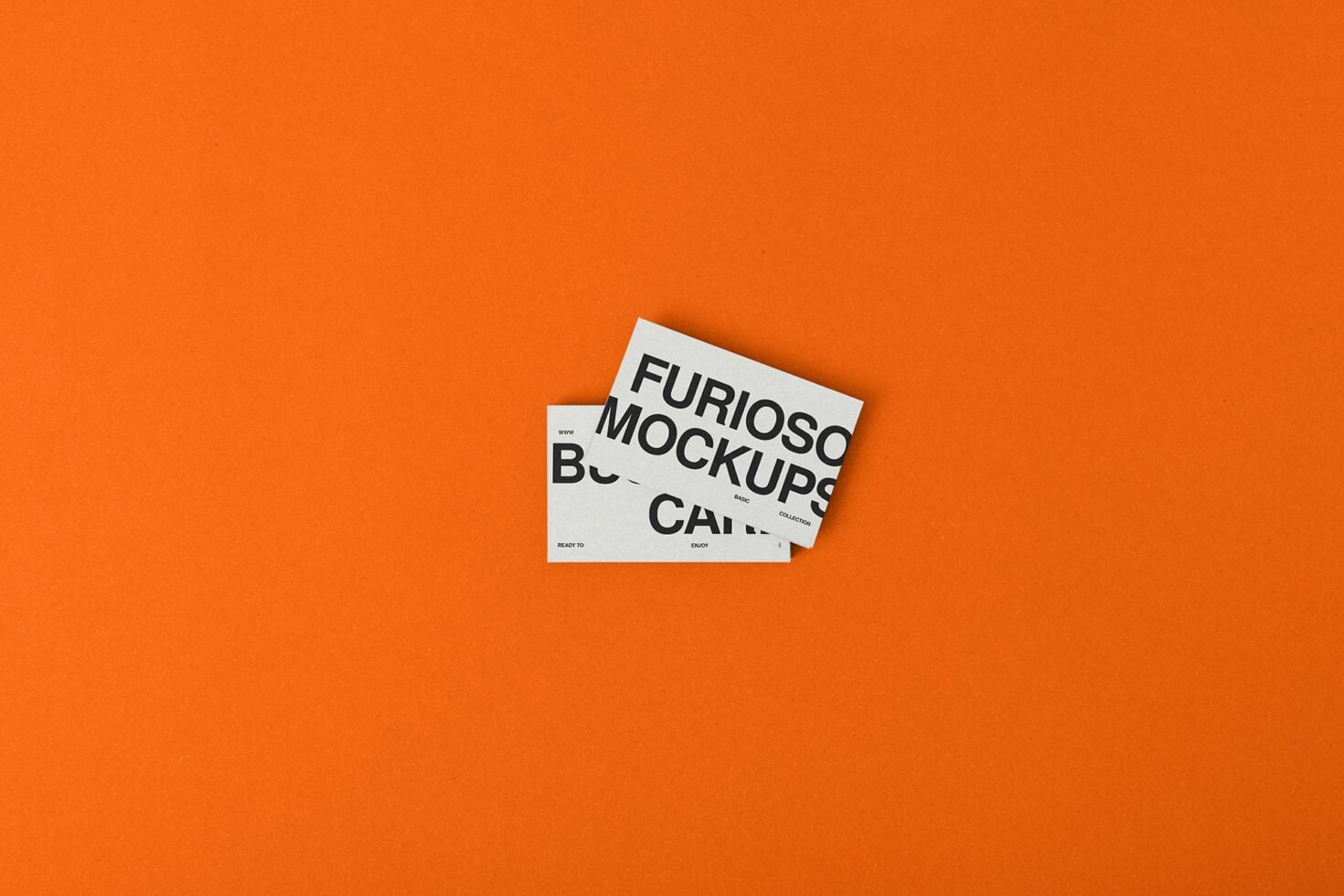 White business card mockup on bright orange surface showing typography