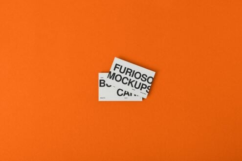 White business card mockup on bright orange surface showing typography