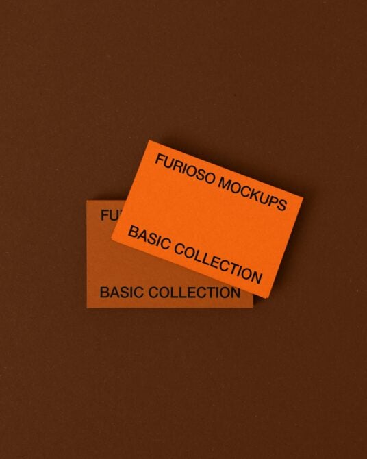 Two tilted business cards on brown background with orange blue text layouts