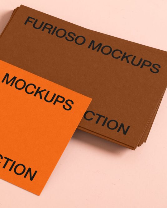 Stacked brown kraft cards with orange label on soft pink background