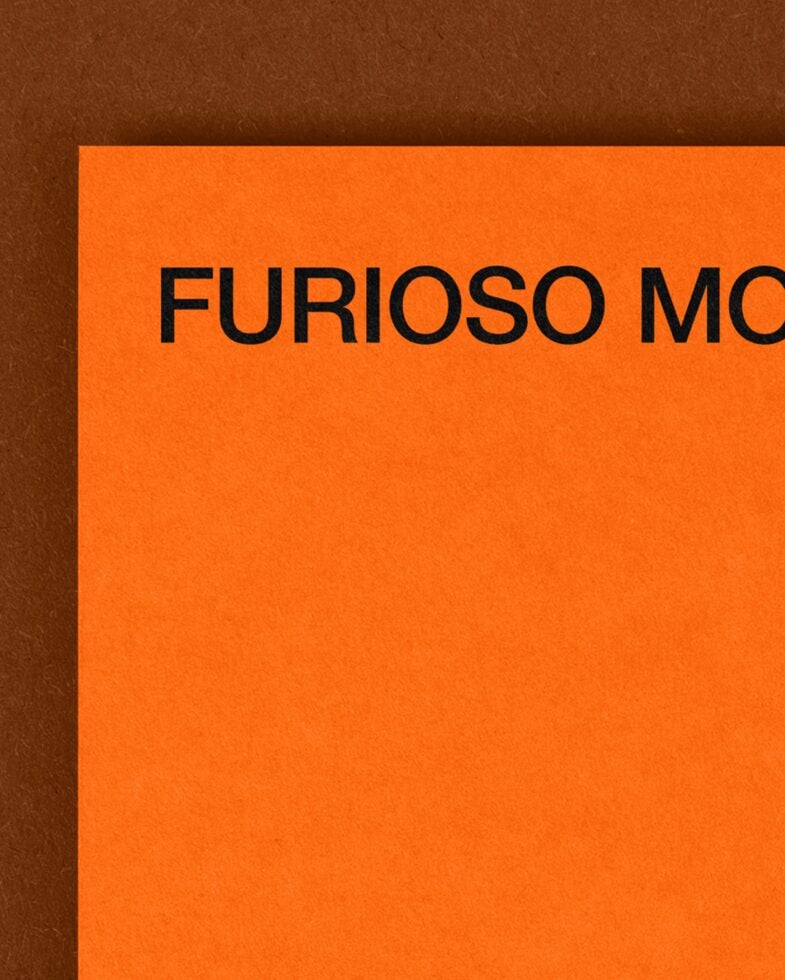 Bright orange card detail showing partial black text on brown textured surface