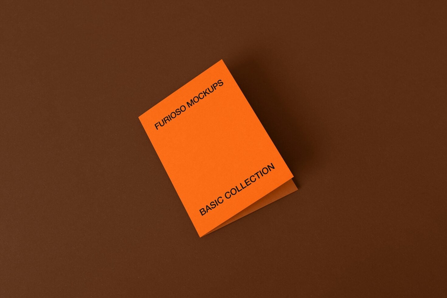Orange folded card mockup on brown surface with subtle shadow
