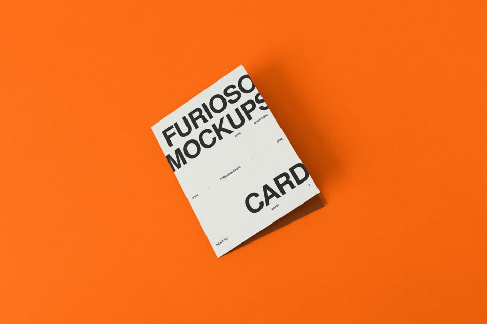 White card mockup on bright orange background flat lay